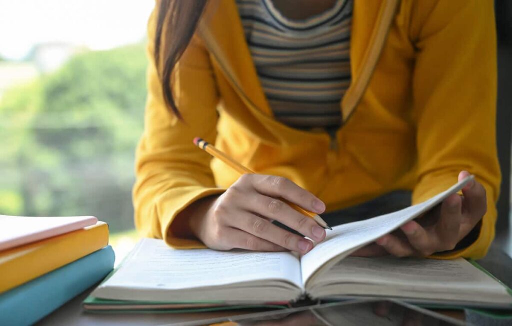 Student reading and taking notes preparing for an exam