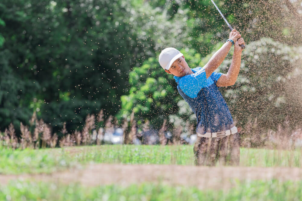 Student at a golf course swinging | Command Education
