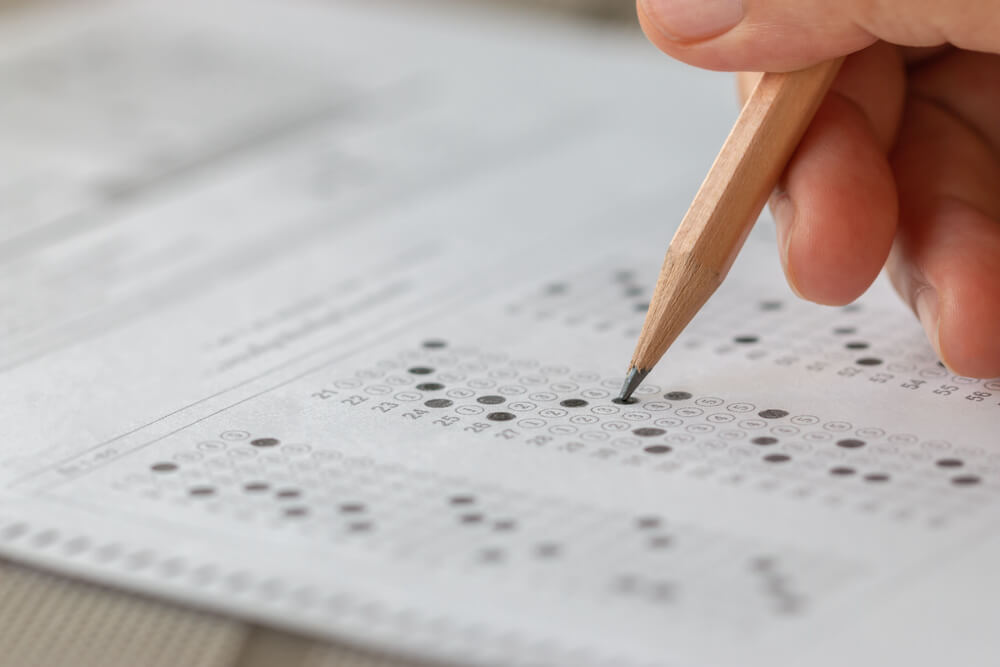 The SAT Is Going Digital and Getting Shorter: 'The Best Possible Option for Students' The College Board announced the SAT will soon be two hours long and that students will get scores back within days, Student hand testing doing test exam with pencil drawing selected choices on answer sheet in school final exams at college or university. Taking multiple choice for assessment in examination classroom